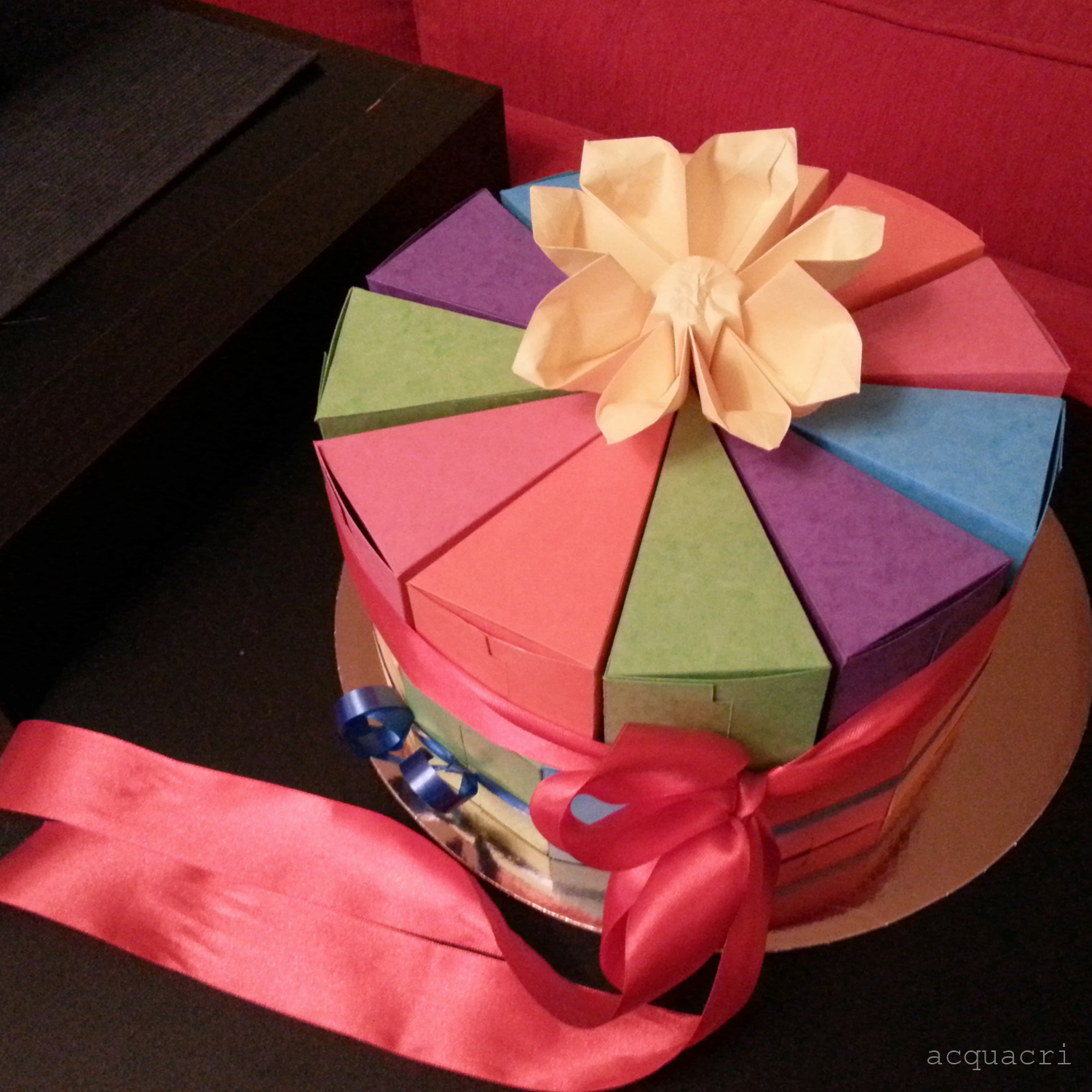 Visione della torta sistemata su due piani, con fiore in origami al centro